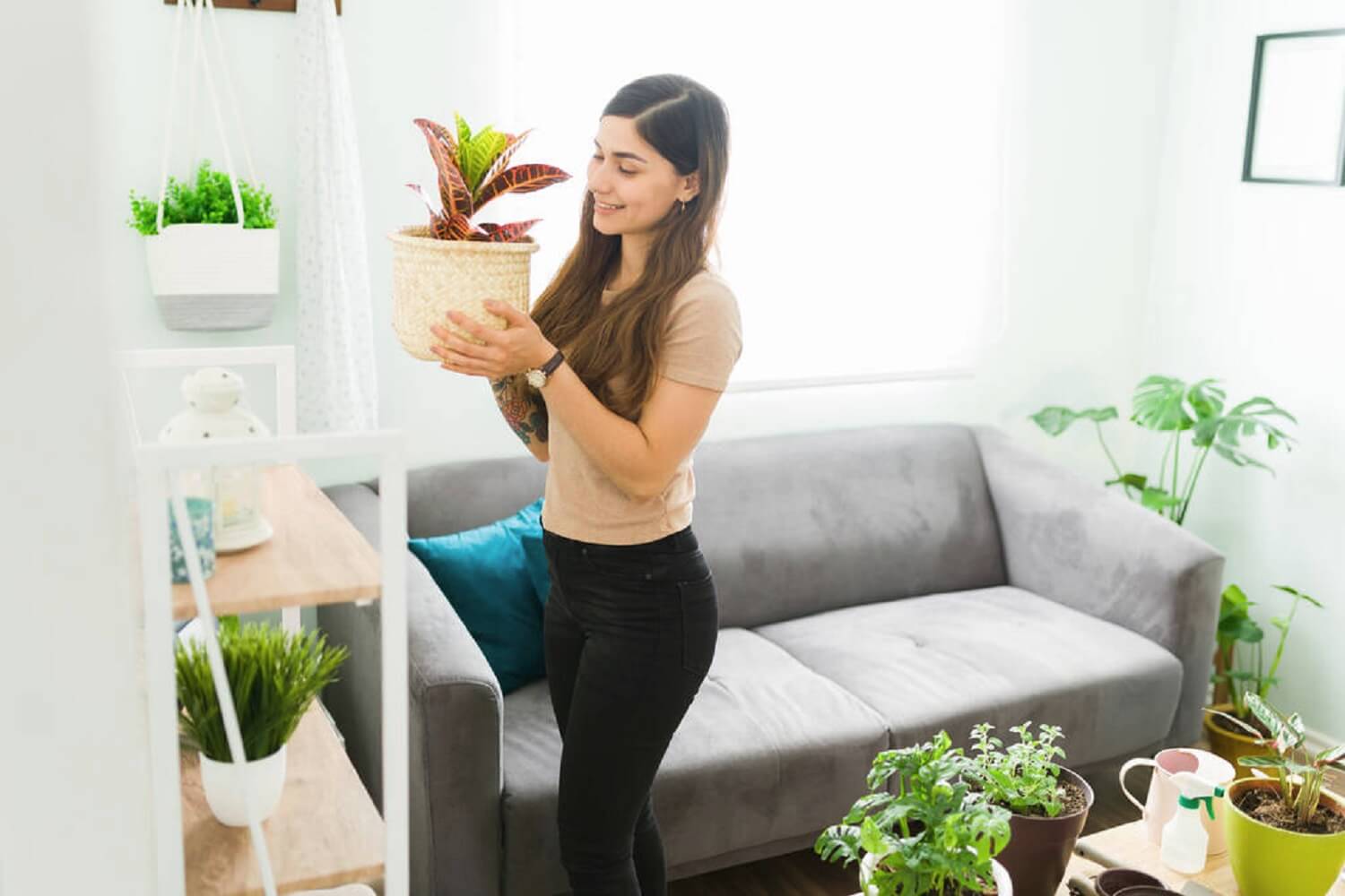 Woman holding a pot with an artificial plant in it