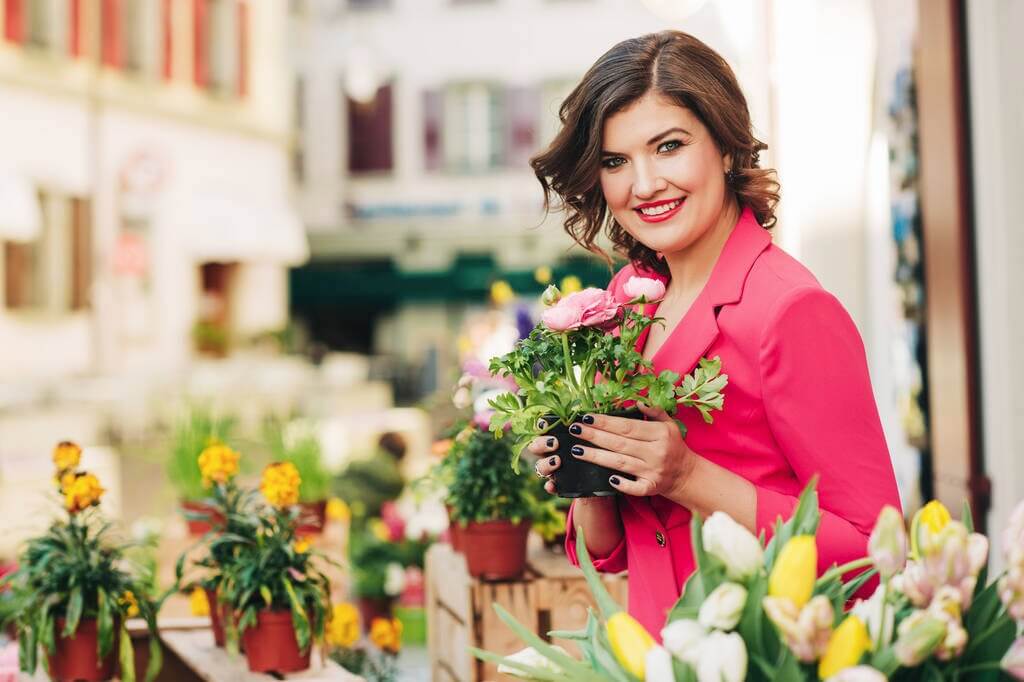 Smiling woman holding artificial flowers