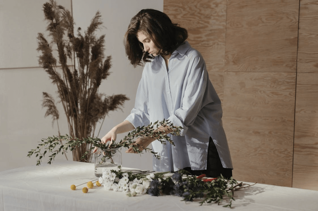 woman arranging flowers for a bouquet