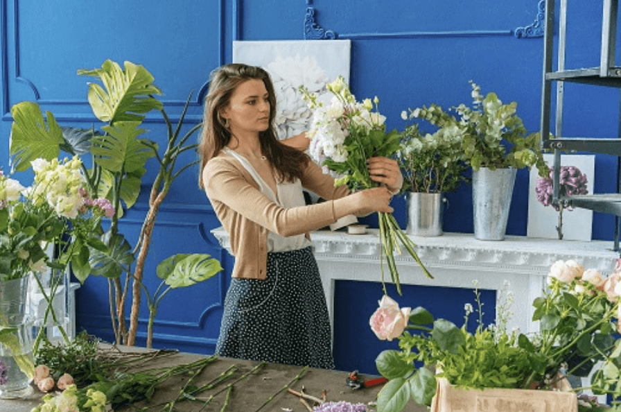 florist looking at white faux flowers