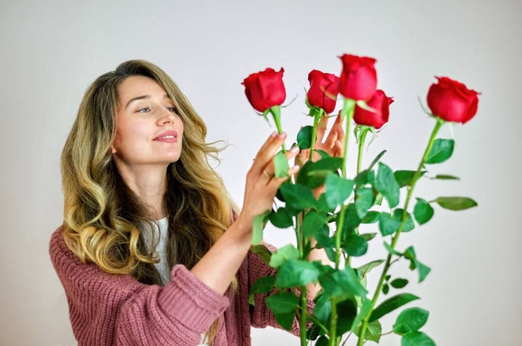 Lady holding red rose stems